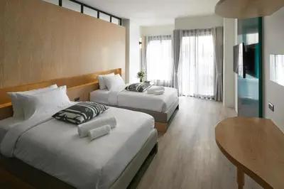 a hotel room with two beds and a table at Hotel Sapin in Pom Prap