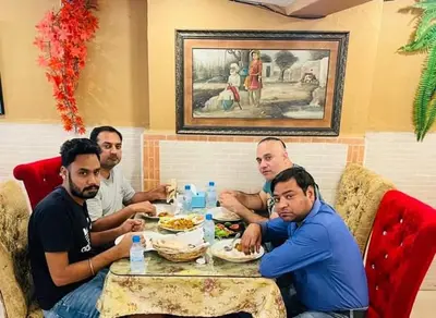 a group of men sitting at a table eating food at Miracle Gallery Hotel in Makkasan