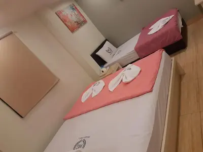 a bedroom with two beds with pink and white sheets at Miracle Gallery Hotel in Makkasan