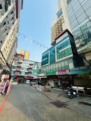 an empty street in a city with tall buildings at Miracle Gallery Hotel in Makkasan