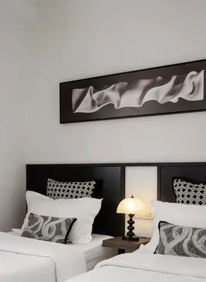 a bedroom with two beds with white and black at CASA BLANCA Dusit in Dusit