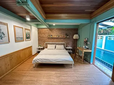 a bedroom with a bed and a table and a pool at T-House BKK 2Floors near BTS with swimming pool and free Wifi in Khlong Toei