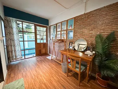 a room with a desk with a mirror and a brick wall at T-House BKK 2Floors near BTS with swimming pool and free Wifi in Khlong Toei