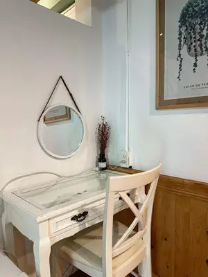 a dressing table with a mirror on a wall at T-House BKK 2Floors near BTS with swimming pool and free Wifi in Khlong Toei