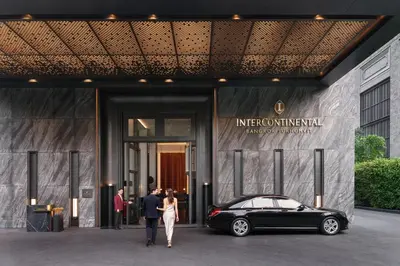 a group of people walking outside of a building with a car at InterContinental Bangkok Sukhumvit by IHG in Bangkok