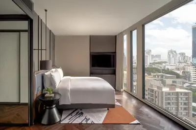 a bedroom with a white bed and a large window at InterContinental Bangkok Sukhumvit by IHG in Bangkok