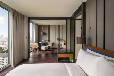 a bedroom with a bed and a living room at InterContinental Bangkok Sukhumvit by IHG in Bangkok