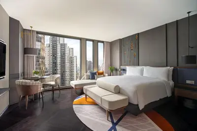 a bedroom with a large bed and a living room at InterContinental Bangkok Sukhumvit by IHG in Bangkok