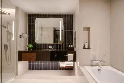 a bathroom with a tub and a sink and a mirror at InterContinental Bangkok Sukhumvit by IHG in Bangkok