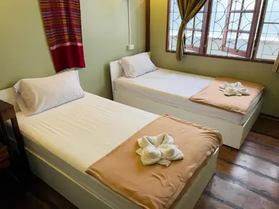 two beds with flowers on them in a room at DonMueang Boutique House DonMueang Airport in Bangkok