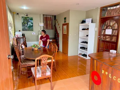 a woman sitting at a table in a room at DonMueang Boutique House DonMueang Airport in Bangkok