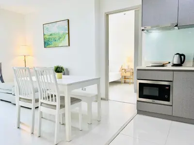 a white kitchen with a white table and chairs at Rhythm sukhumvit 36 two bedrooms in Bangkok