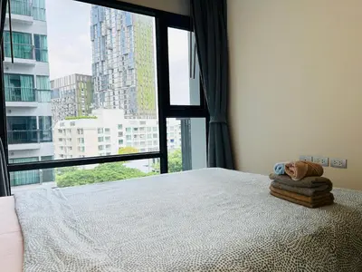 a bedroom with a bed with a large window at Rhythm sukhumvit 36 two bedrooms in Bangkok