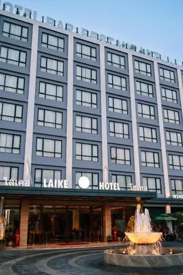 a hotel with a fountain in front of a building at Laike Hotel in Bangkok