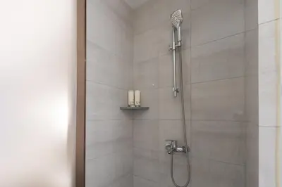 a bathroom with a shower with a shower head at Laike Hotel in Bangkok