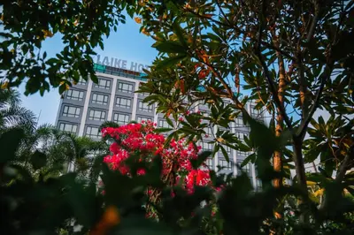 a building with a sign on top of it with pink flowers at Laike Hotel in Bangkok