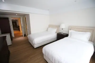 two beds in a hotel room with white sheets at SASHA HOUSE in Ban Yang
