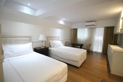 a hotel room with two beds and a television at SASHA HOUSE in Ban Yang