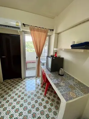 a room with a table with a tv and a window at Ratanawong Place 815 in Bangkok