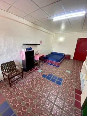 a room with a bed and a table and a bench at Ratanawong Place 403 in Bangkok