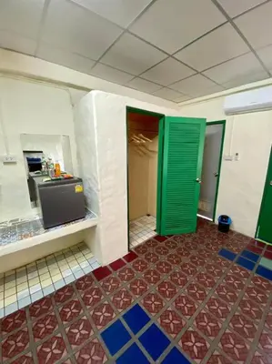 a kitchen with green doors and a red floor at Ratanawong Place 403 in Bangkok