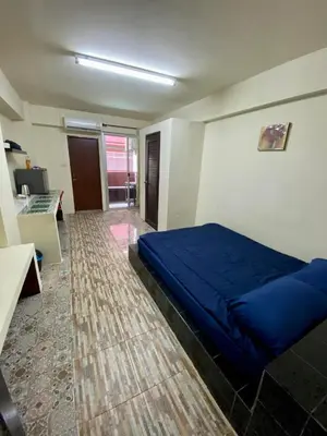 a bedroom with a blue bed and a desk at Ratanawong Place 804 in Bangkok