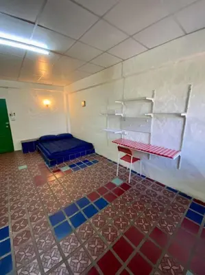 a room with a blue bed and shelves on the wall at Ratanawong Place 406 in Bangkok