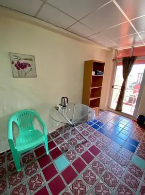 a room with a glass table and a green chair at Ratanawong Place 404 in Bangkok