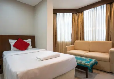 a bedroom with a bed and a chair and a window at IRAQI HOTEL in Makkasan