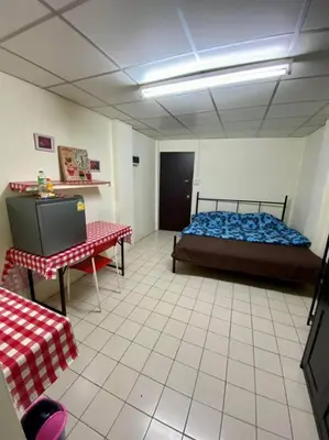 a room with a bed and a table and a tv at Ratanawong Place 334 in Bangkok