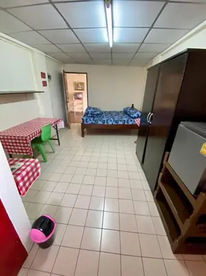a hallway of a room with a bed and a table at Ratanawong Place 557 in Bangkok