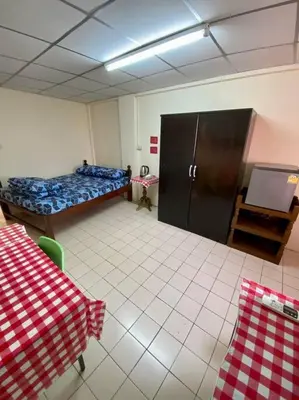 a room with a bedroom with a bed and a table at Ratanawong Place 557 in Bangkok