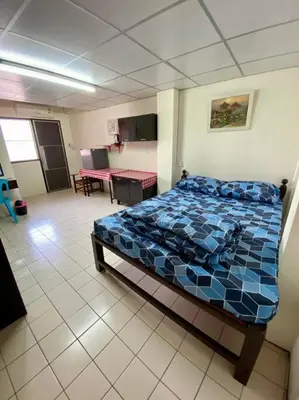 a bedroom with a bed with a blue comforter at Ratanawong Place 560 in Bangkok
