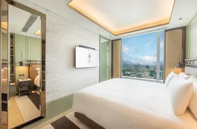 a bedroom with a large bed and a large window at Eastin Grand Hotel Phayathai in Bangkok