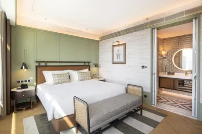 a hotel room with a bed and a chair at Eastin Grand Hotel Phayathai in Bangkok