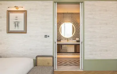 a room with a door leading to a bathroom at Eastin Grand Hotel Phayathai in Bangkok