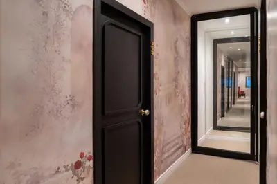 a hallway with a black door and a mirror at Baansuansao in Bang Rak