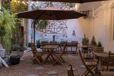 a patio with tables and chairs and an umbrella at Baansuansao in Bang Rak