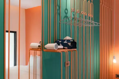 a bathroom with green and orange walls and a mirror at Speck Bangkok in Bangkok