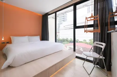a bedroom with a bed and a large window at Speck Bangkok in Bangkok