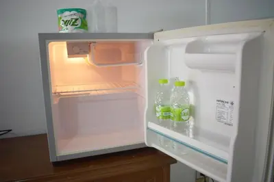an open refrigerator with bottles of water in it at My Hotel Bangkok Noi in Bangkok Noi