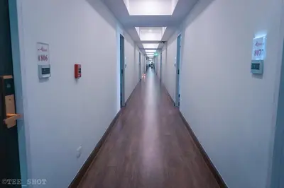 a hallway of an office building with a wooden floor at Siam Best Inn in Makkasan