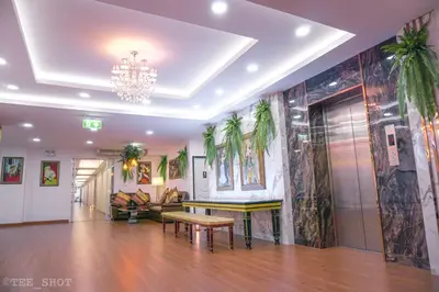a living room with a table and a chandelier at Siam Best Inn in Makkasan
