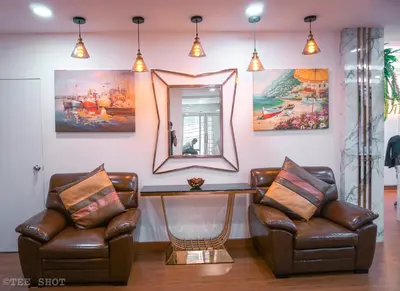 a living room with two chairs and a mirror at Siam Best Inn in Makkasan