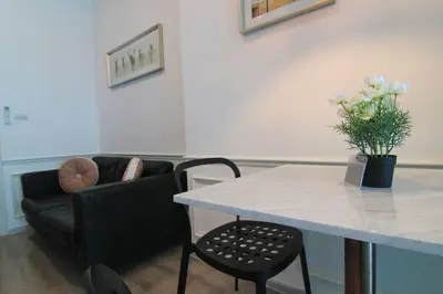 a living room with a table and a couch at New Condo, Hi-Speed Wi-Fi, Gym Pool, near Lam Sali MRT in Bangkok