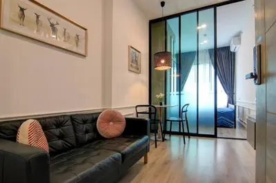 a living room with a leather couch and a table at New Condo, Hi-Speed Wi-Fi, Gym Pool, near Lam Sali MRT in Bangkok