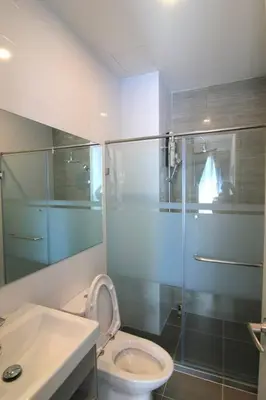 a bathroom with a toilet and a glass shower at New Condo, Hi-Speed Wi-Fi, Gym Pool, near Lam Sali MRT in Bangkok