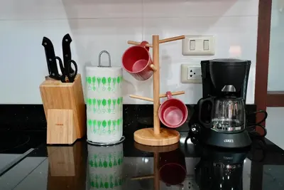 a kitchen counter with a coffee maker and utensils at Baan Sukhumvit14 in Bangkok