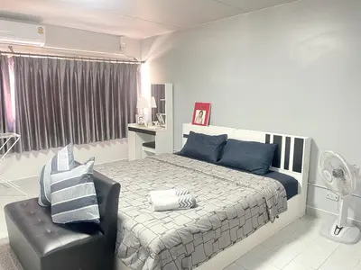 a bedroom with a bed and a black chair at Impact Arena C3 Milo in Nonthaburi