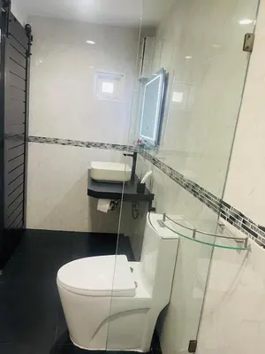 a bathroom with a white toilet and a sink at Thonglor Suites Hotel in Bangkok